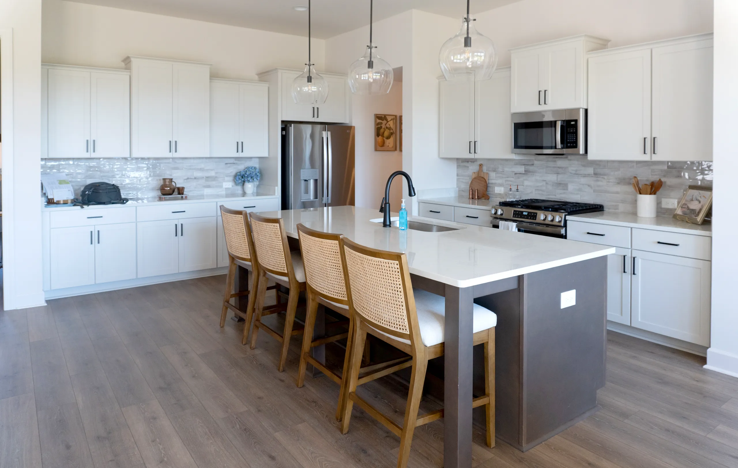 Modern white kitchen with glossy gray tile backsplash and quartz island